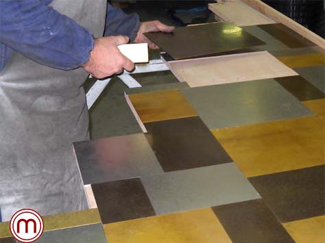 Rivestimento bancone per un ristorante milanese, formato da un patchwork in vari metalli martellati a mano