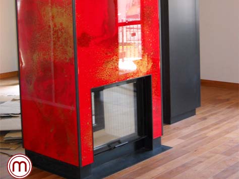 L’apposito rivestimento in resina rossa con traccie oro, ha reso questo caminetto un pezzo artistico unico e di pregio. Realizzato in collaborazione con l’artista Lorenza Soldà